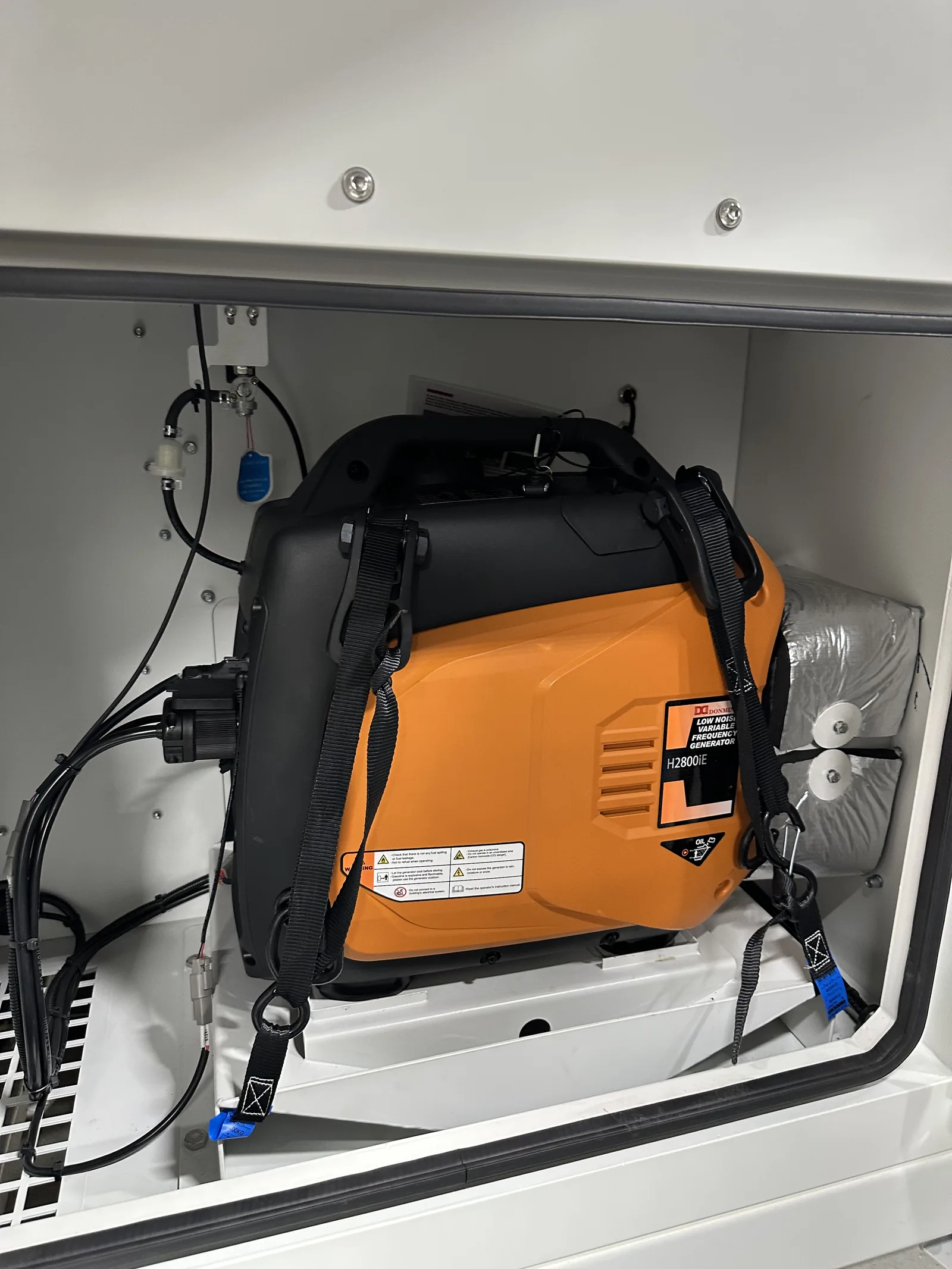 The onboard gasoline generator in its compartment, strapped down